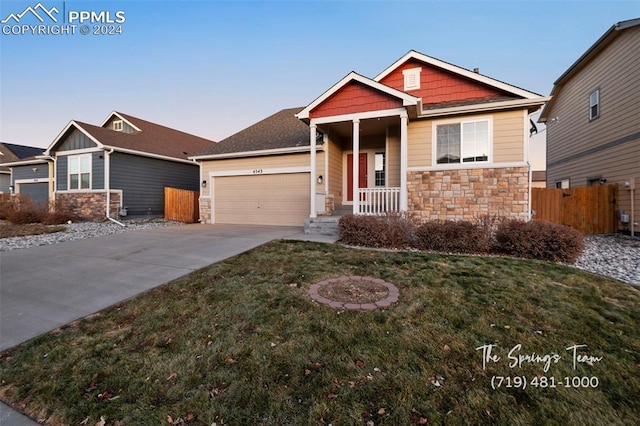 craftsman-style house featuring a yard and a garage