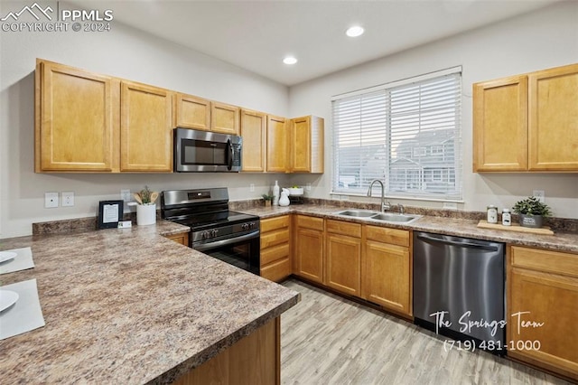 kitchen featuring appliances with stainless steel finishes, light wood-type flooring, and sink