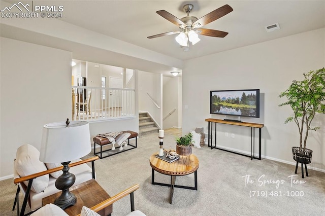 carpeted living room with ceiling fan