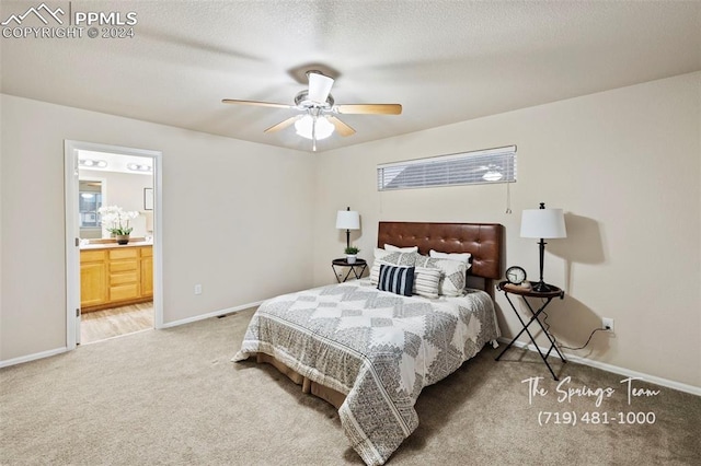 carpeted bedroom with a textured ceiling, connected bathroom, and ceiling fan