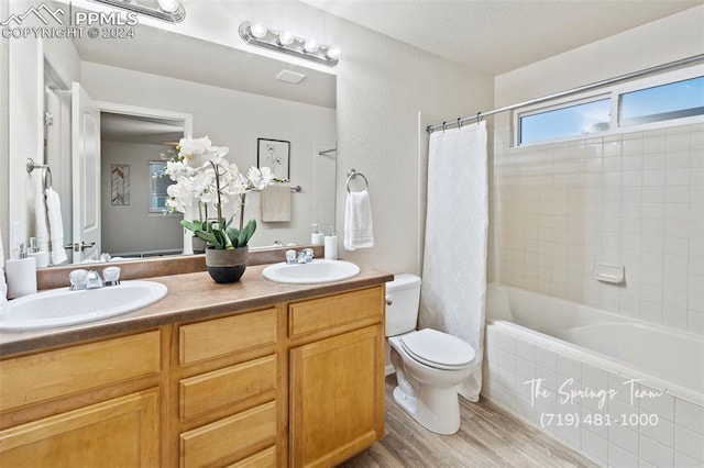 full bathroom featuring shower / tub combo with curtain, vanity, wood-type flooring, and toilet