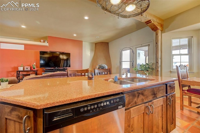 kitchen with light stone countertops, dishwasher, sink, an island with sink, and light tile patterned flooring