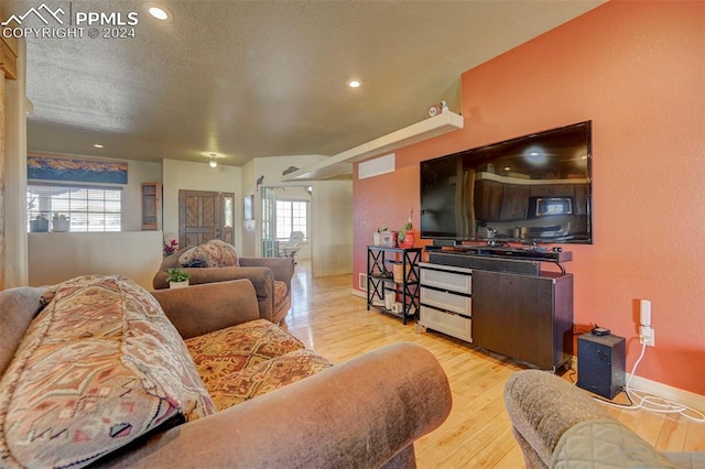 living room with light hardwood / wood-style flooring and a textured ceiling