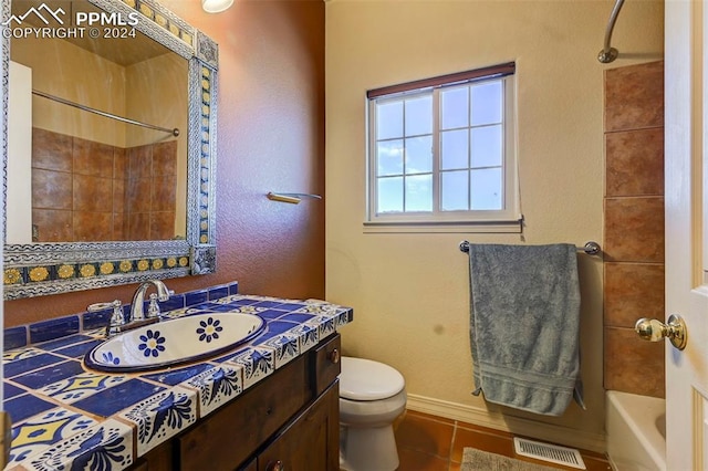 full bathroom featuring tile patterned flooring, vanity, toilet, and tiled shower / bath combo