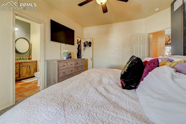 bedroom with light tile patterned floors, ensuite bath, and ceiling fan