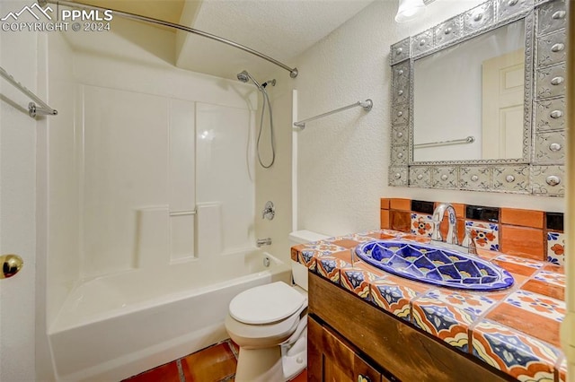 full bathroom with vanity, a textured ceiling, bathing tub / shower combination, and toilet