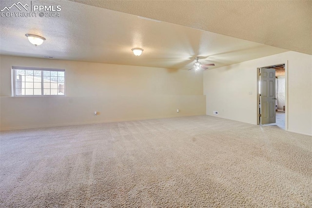 empty room featuring ceiling fan, carpet, and a textured ceiling