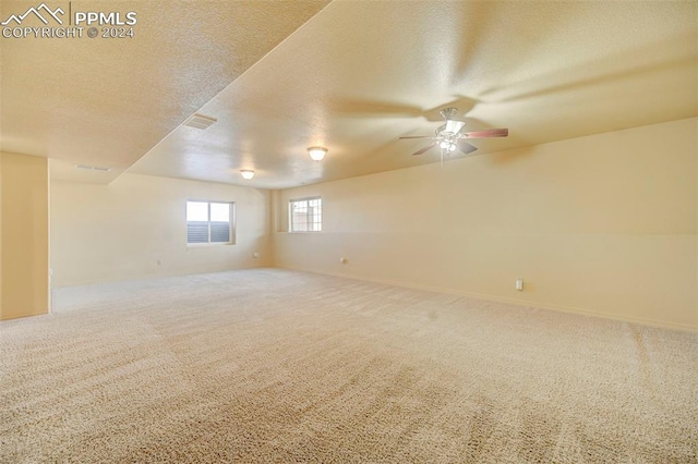 spare room with carpet flooring, a textured ceiling, and ceiling fan