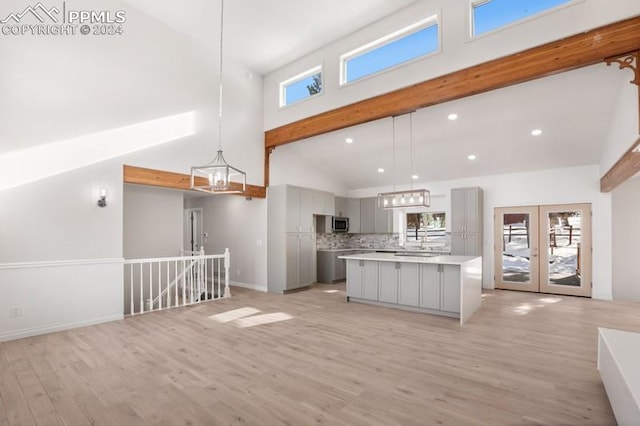 kitchen featuring gray cabinetry, plenty of natural light, a spacious island, and high vaulted ceiling