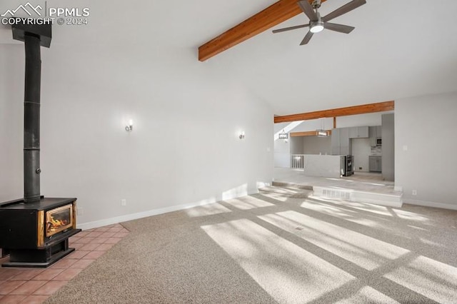 carpeted living room with beam ceiling, a wood stove, ceiling fan, and high vaulted ceiling