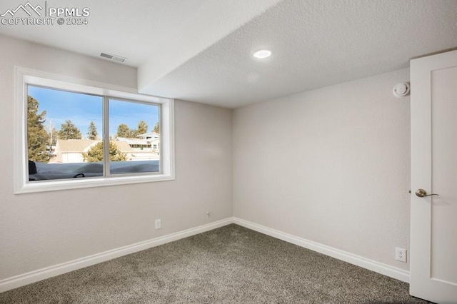 carpeted spare room with a textured ceiling