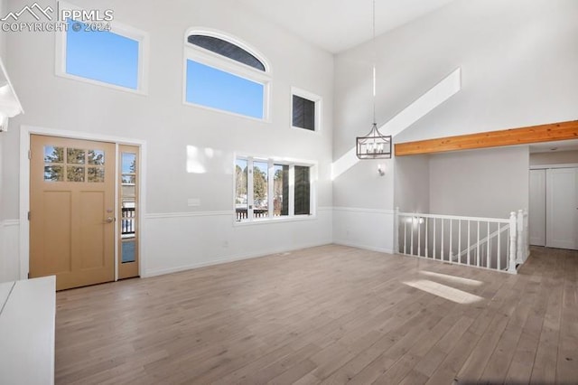 unfurnished living room with a high ceiling and hardwood / wood-style floors