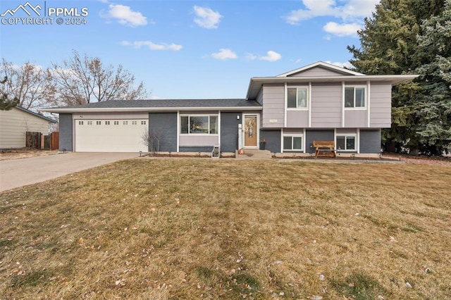 split level home featuring a garage and a front lawn