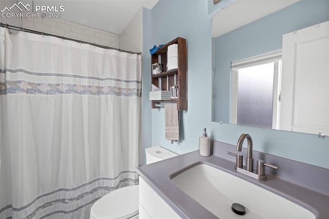 bathroom with vanity, a shower with shower curtain, and toilet