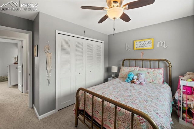 carpeted bedroom with ceiling fan and a closet