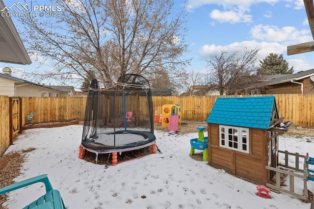 snow covered playground with a trampoline