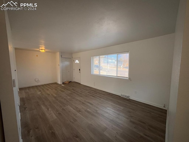 unfurnished living room featuring dark hardwood / wood-style floors