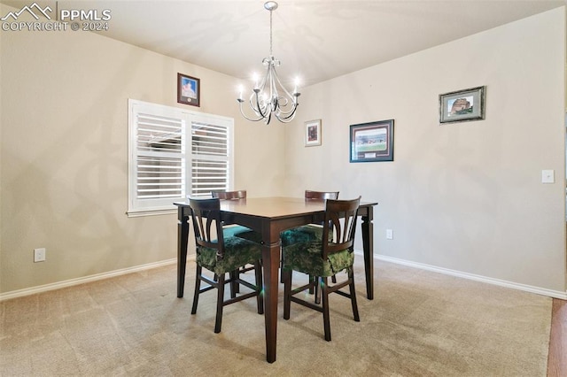 dining space featuring a notable chandelier and light carpet