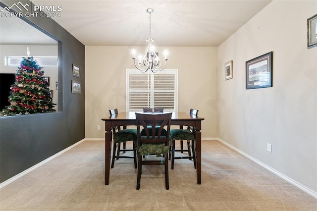 carpeted dining area featuring an inviting chandelier