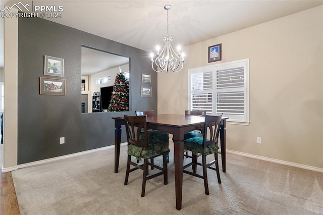 carpeted dining area featuring an inviting chandelier and a wealth of natural light