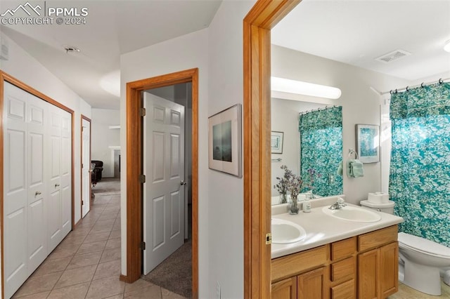 bathroom featuring tile patterned flooring, vanity, and toilet