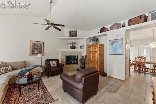 tiled living room featuring a tiled fireplace, ceiling fan, and vaulted ceiling