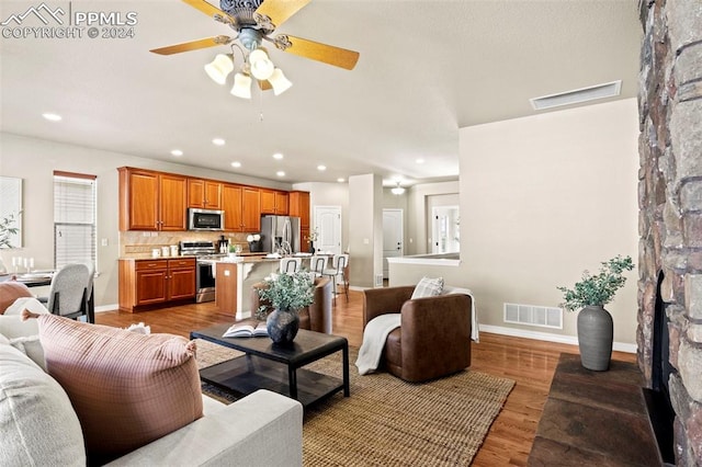 living room featuring wood-type flooring and ceiling fan