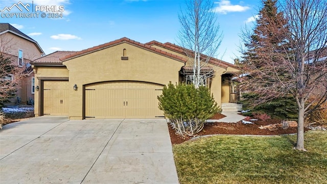 mediterranean / spanish house with a garage and a front yard