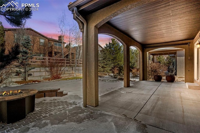 patio terrace at dusk featuring a fire pit