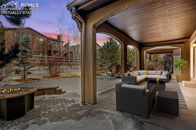 patio terrace at dusk featuring an outdoor living space with a fire pit