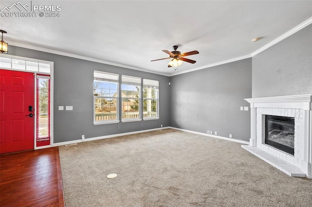 unfurnished living room featuring dark hardwood / wood-style flooring, a brick fireplace, ceiling fan, and ornamental molding