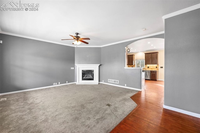 unfurnished living room with dark hardwood / wood-style flooring, ceiling fan, and ornamental molding