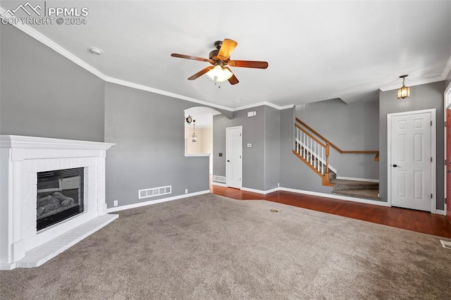 unfurnished living room with a brick fireplace, ceiling fan, dark hardwood / wood-style floors, and ornamental molding