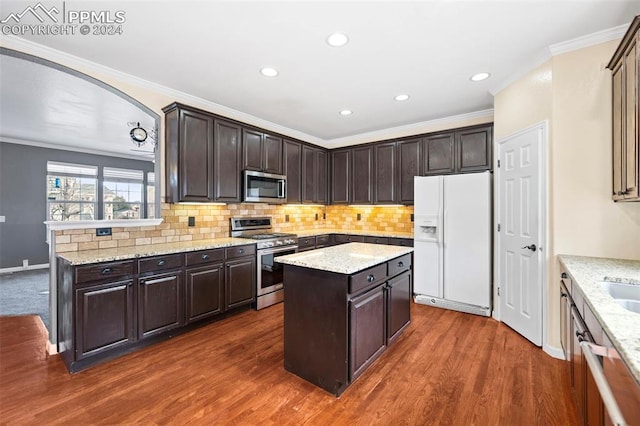 kitchen featuring a center island, dark hardwood / wood-style floors, crown molding, dark brown cabinets, and appliances with stainless steel finishes