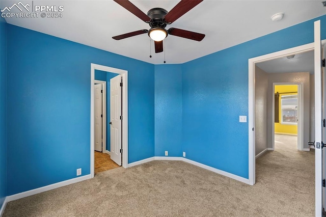 carpeted empty room featuring ceiling fan