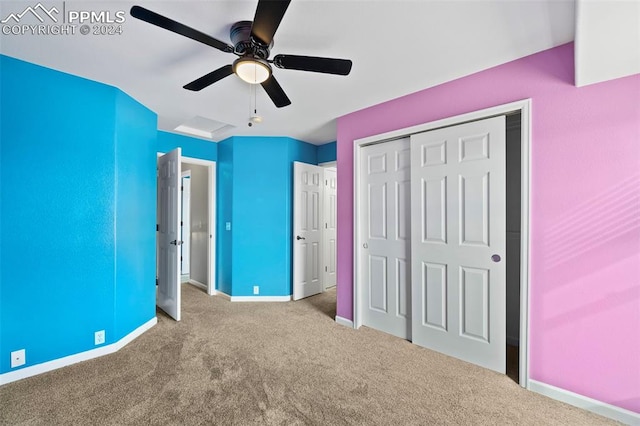 unfurnished bedroom with ceiling fan, light carpet, and a closet