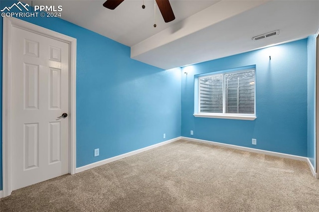 carpeted spare room featuring ceiling fan