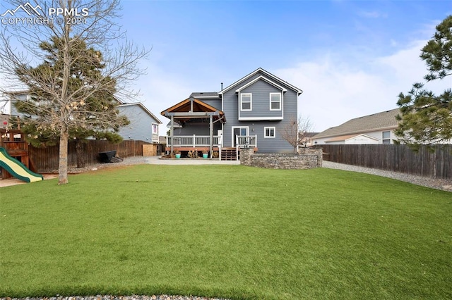 rear view of property featuring a lawn and a patio