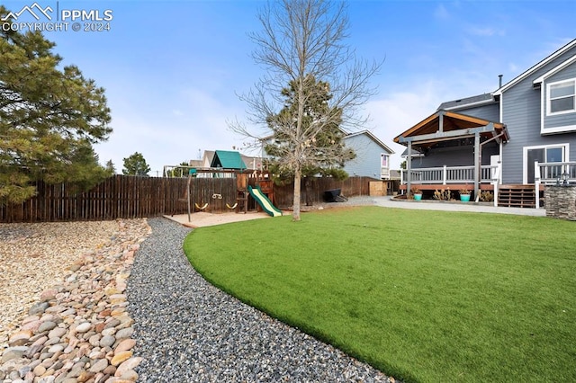 view of yard with a playground and a deck