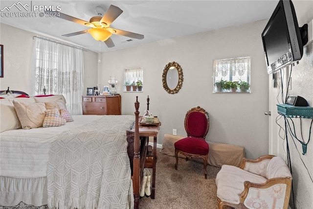 carpeted bedroom featuring multiple windows and ceiling fan