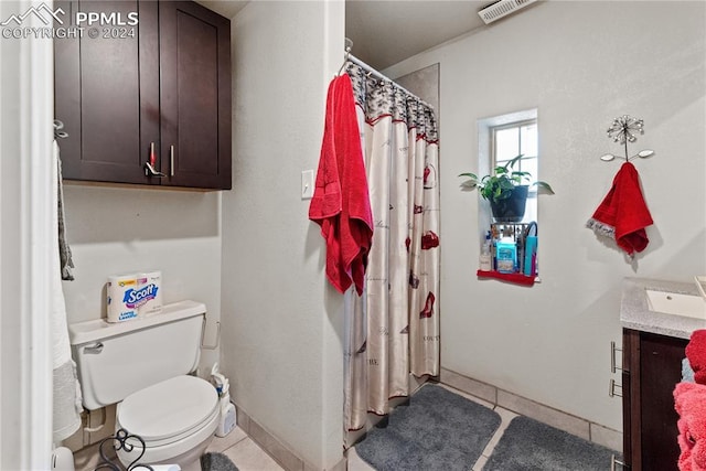 bathroom featuring baseboard heating, tile patterned flooring, vanity, and toilet