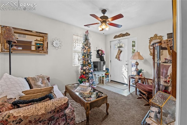 carpeted living room with ceiling fan