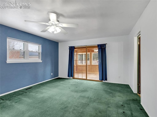 empty room featuring ceiling fan and dark colored carpet