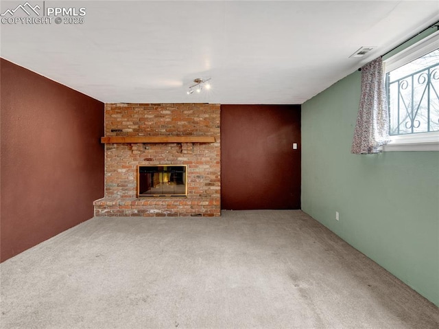 unfurnished living room featuring a brick fireplace and carpet floors