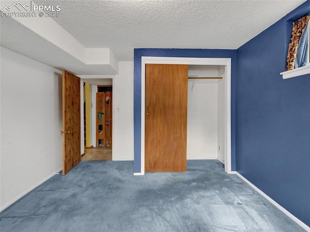 unfurnished bedroom featuring carpet floors, a textured ceiling, and a closet