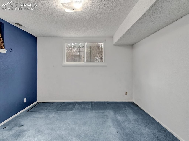 carpeted empty room with a textured ceiling