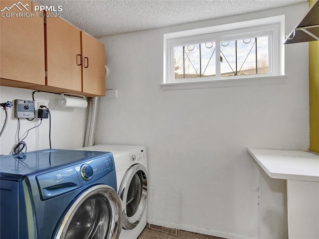 laundry room with cabinets, a textured ceiling, and independent washer and dryer