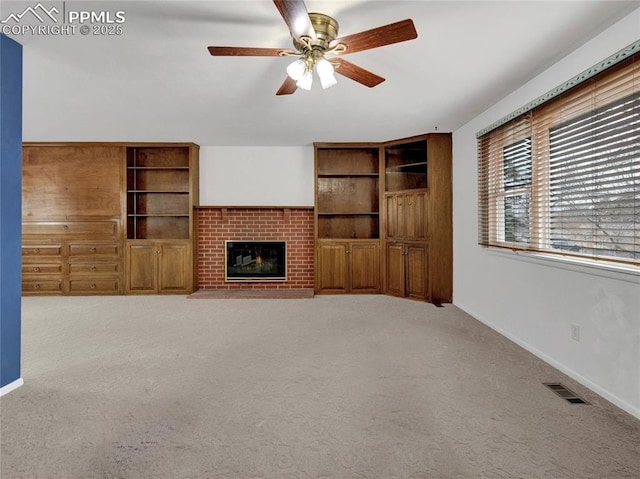 unfurnished living room with ceiling fan, a fireplace, and carpet floors