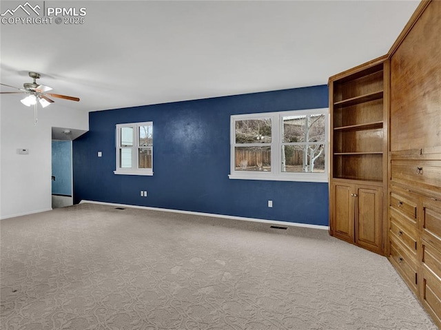 unfurnished living room featuring light colored carpet and ceiling fan