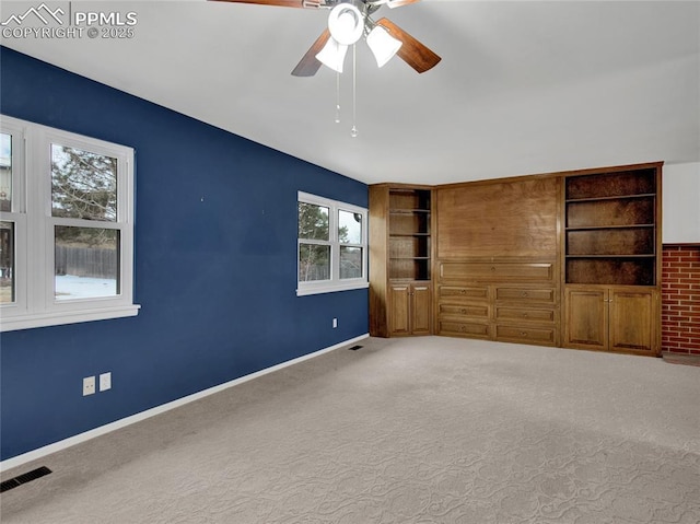 unfurnished living room featuring carpet floors and ceiling fan